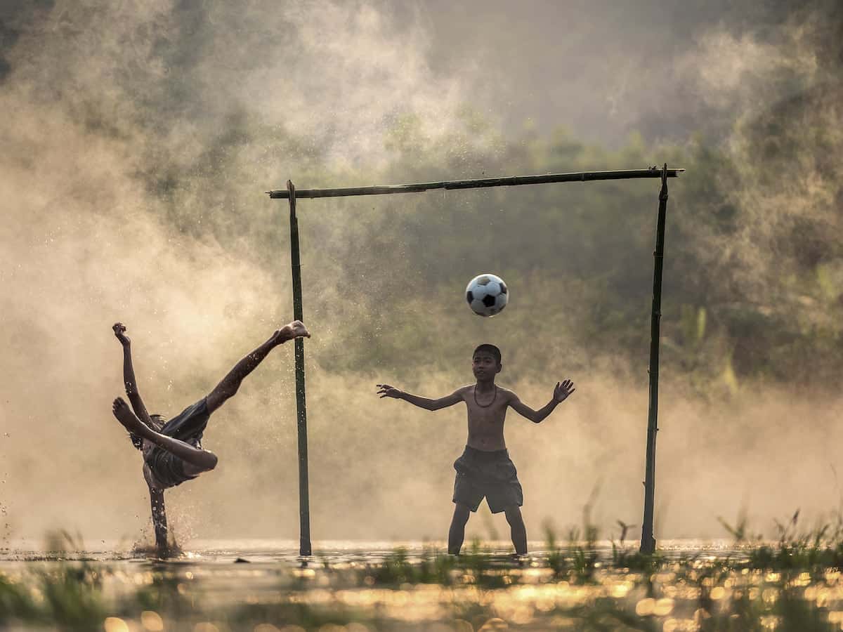 due bambini giocano all'aperto con la palla